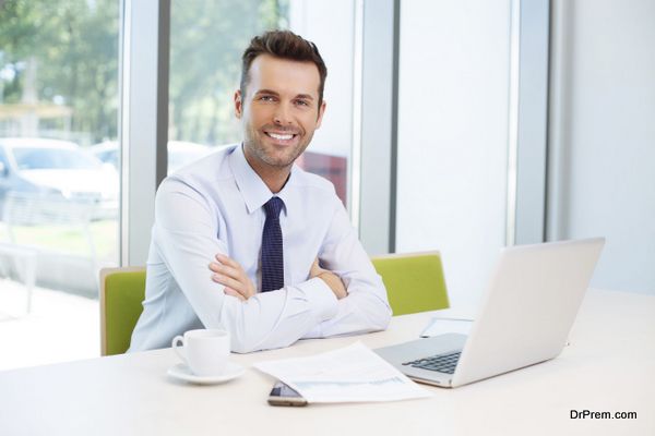 Happy man sitting at desk in the office