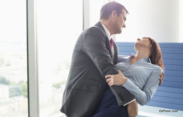 Loving business couple dancing in office