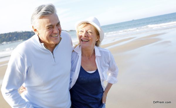 Senior couple walking on the beach in fall season