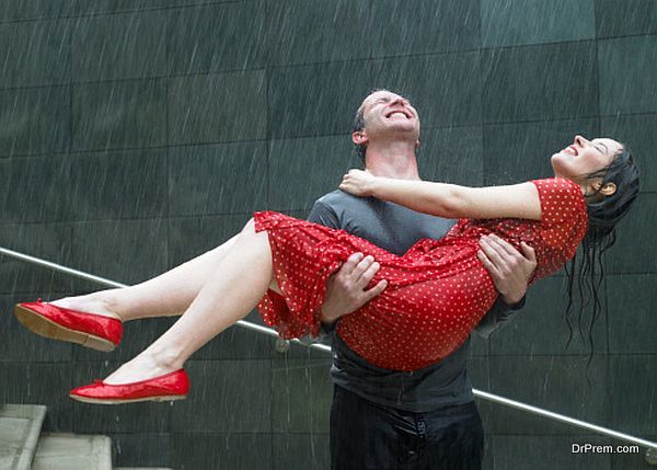 Couple on steps in rain, man carrying young woman, eyes closed