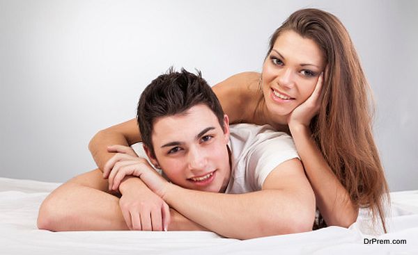 Portrait of happy young couple lying in bed and smiling