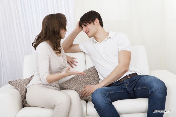 Portrait of couple sitting on sofa having quarrel