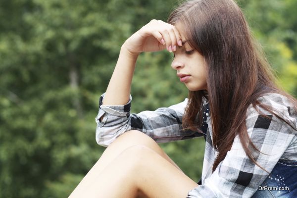 Outdoor portrait of a sad teenage girl looking thoughtful about troubles