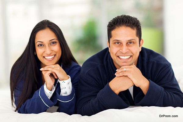 happy indian couple lying on bed