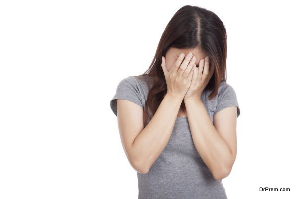 Sad young Asian woman crying with face on palm isolated on white background